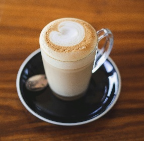 Caffè latte served in a glass cup